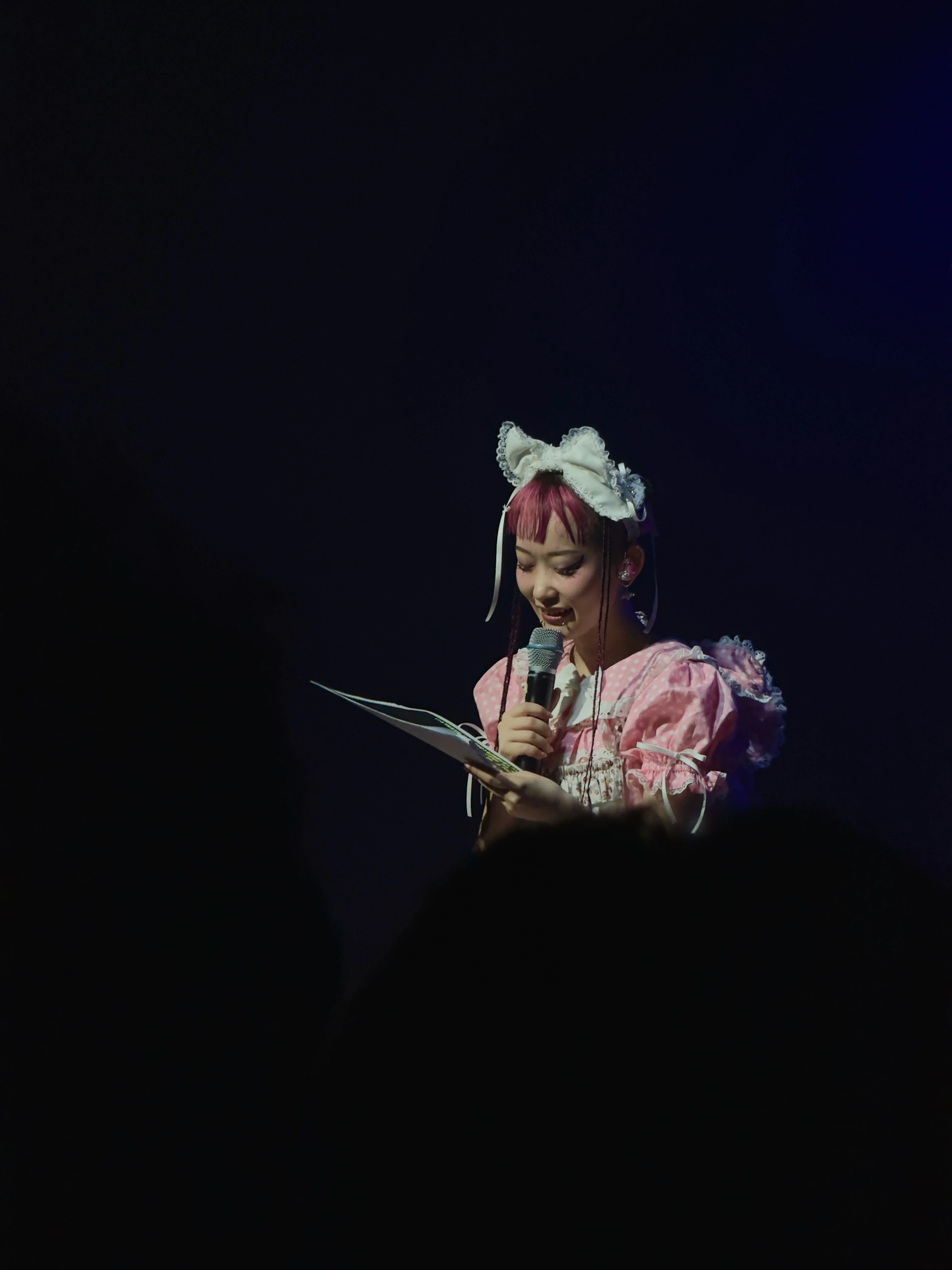 롤리타 패션 복장을 한 WEDNESDAY CAMPANELLA(수요일의 캄파넬라)의 우타하가 원고를 읽으며 무대에서 말하고 있다.