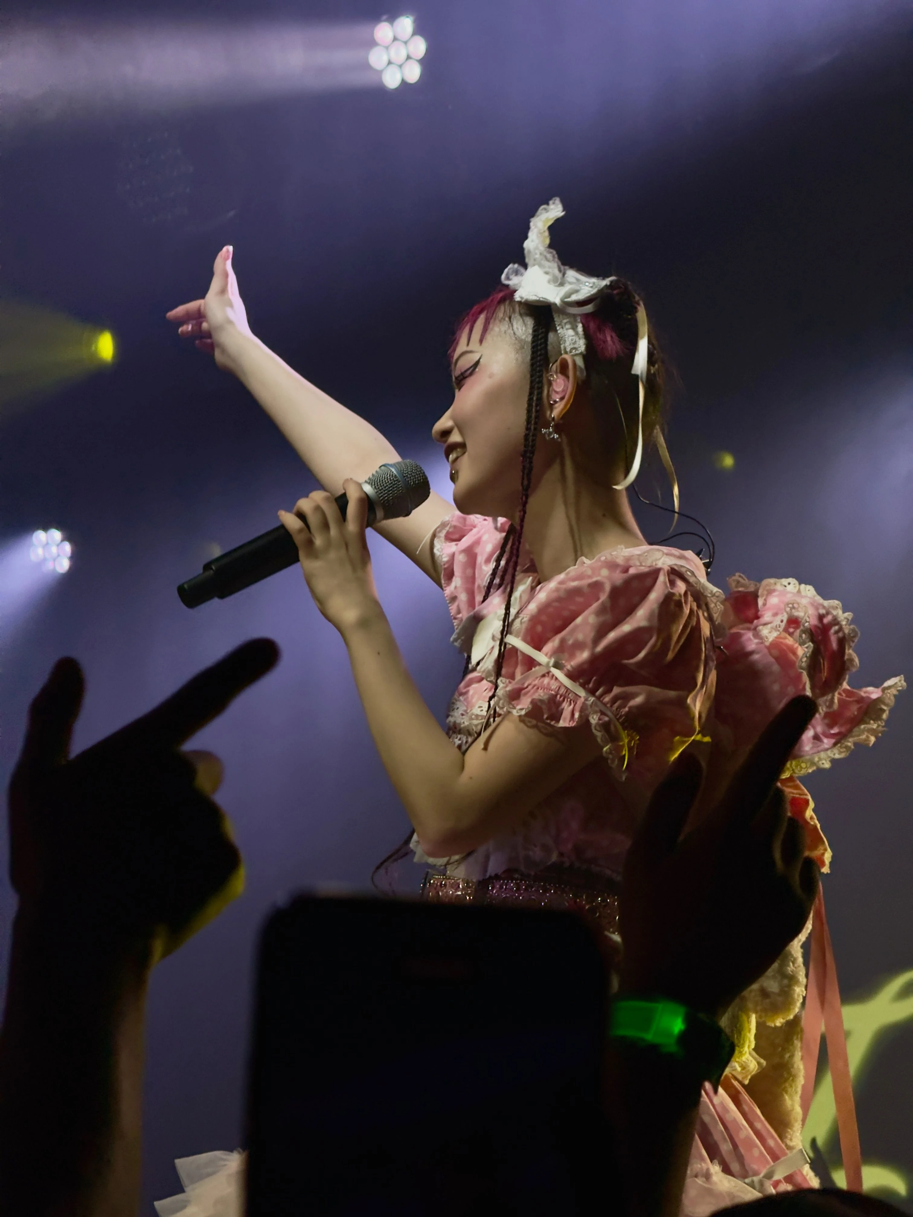 롤리타 패션 복장을 한 WEDNESDAY CAMPANELLA(수요일의 캄파넬라)의 우타하가 왼손에 마이크를 잡은 채로 오른손을 권총 모양으로 만들어 팔을 뻗고 있다. 객석에는 우타하의 오른손을 따라하는 관객들의 손이 보인다.