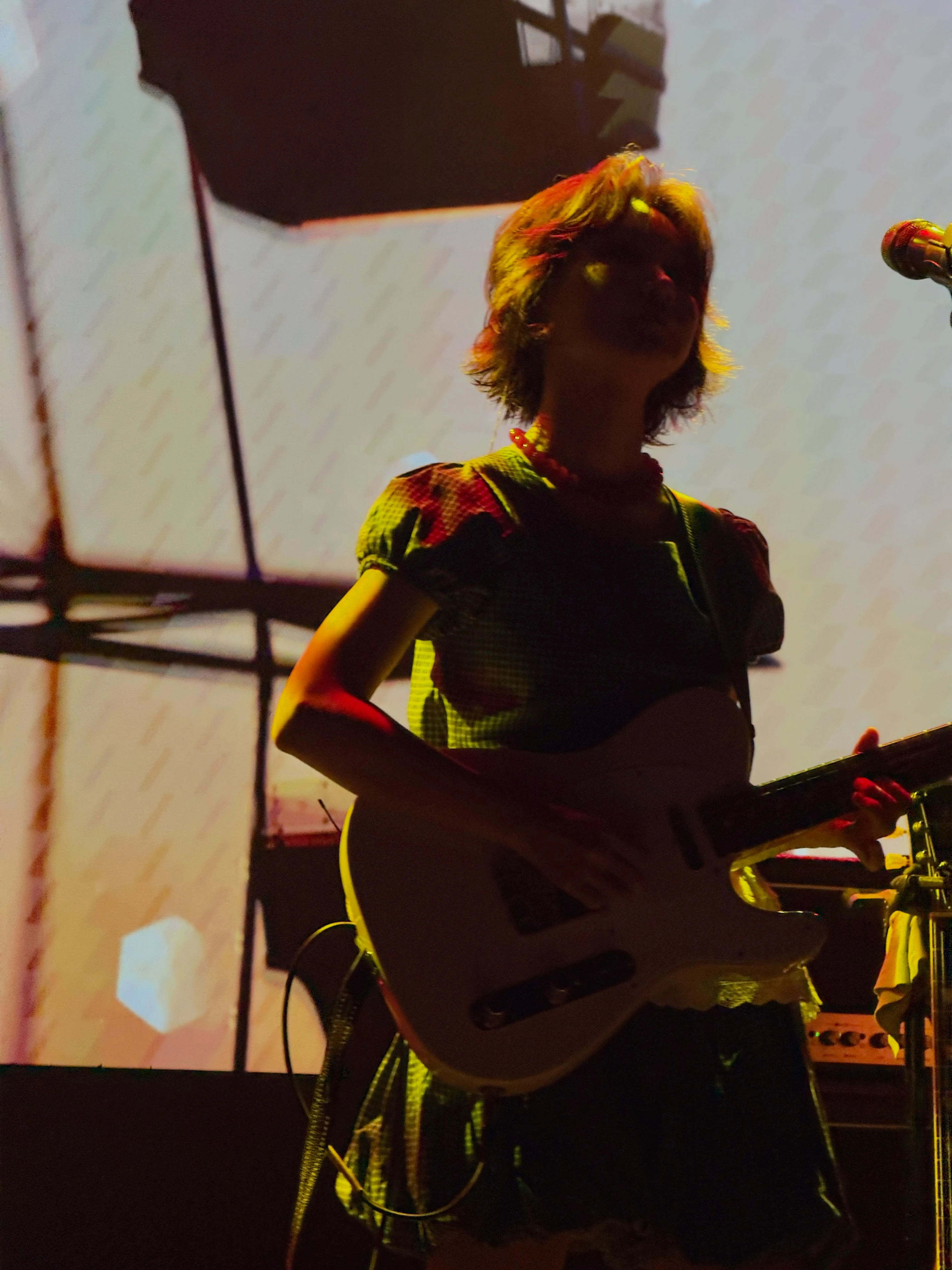 김수영이 일렉트릭 기타를 연주하면서 객석을 멀리 바라보고 있다. 조명은 그의 뒷모습을 은은하게 비추고 있다.