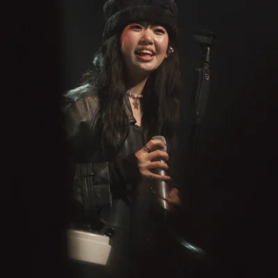 마이크를 쥐고 객석을 바라보며 웃는 윤지영의 모습.