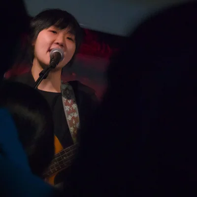 관객석을 바라보면서 베이스 기타를 연주하며 노래를 부르는 싱어송라이터 우희준의 모습.