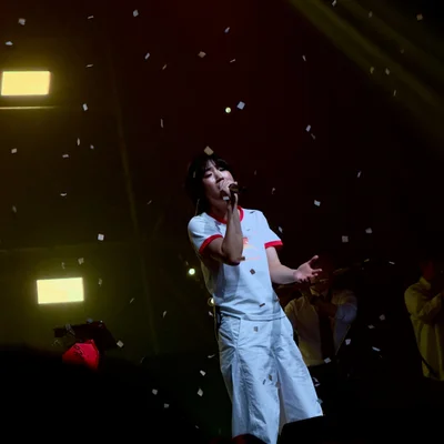 신온유가 마이크를 잡고 노래를 부르며 객석을 쳐다보고 있다. 무대에는 컨페티가 떨어지고 있고, 신온유의 뒤에는 세션의 모습이 보인다.