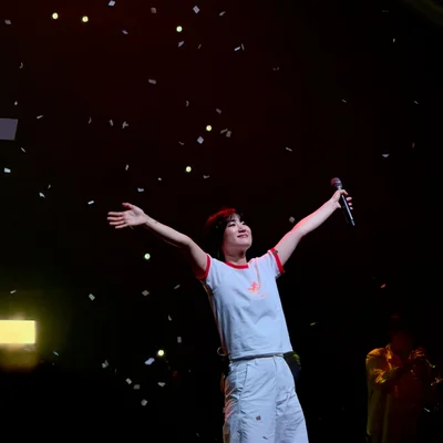 신온유가 관객석을 바라보며 팔을 양옆으로 뻗고 있다. 무대 위에는 컨페티가 떨어지고 있다.