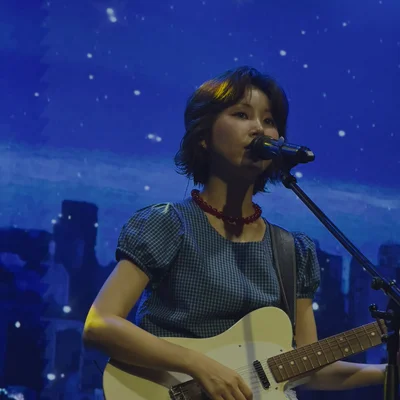 김수영이 일렉트릭 기타를 연주하면서 노래를 부르고 있다.