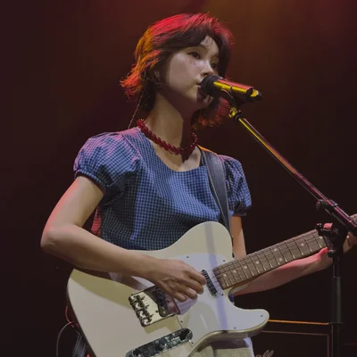 김수영이 일렉트릭 기타를 연주하면서 노래를 부르고 있다.