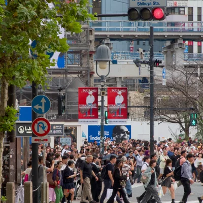 시부야 스크램블 교차로에 많은 사람들이 횡단보도를 건너고 있다.
