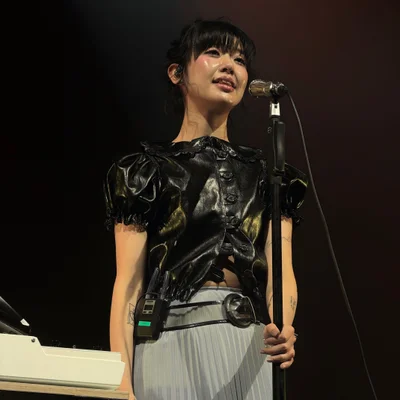 마이크 스탠드를 잡으며 관객석을 바라보고 노래를 부르는 윤지영의 모습.